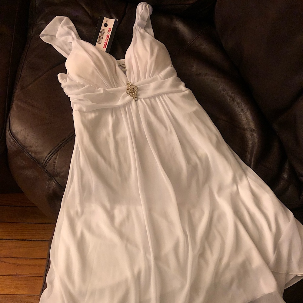 Short white dress with pendant brooch on the middle.